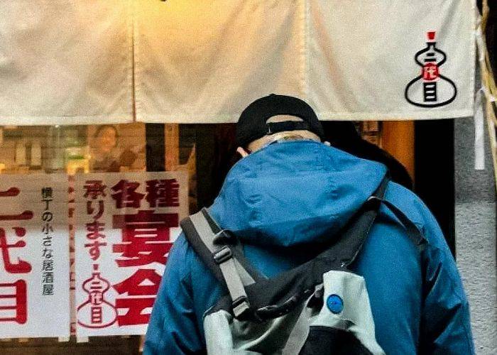 A guest ducking into an izakaya on this Sendai bar hopping tour in the Miyagi Prefecture.